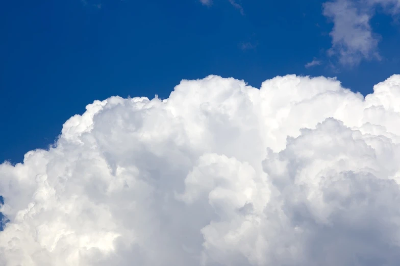 a plane flying through a cloud filled blue sky, a stock photo, shutterstock, stormy clouds outdoor, white cyclops portrait in sky, sitting in a fluffy cloud, stock photo