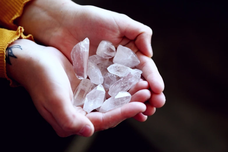 a person holding some ice crystals in their hands, by Maksimilijan Vanka, shutterstock, crystal cubism, many small stones, ancient fairy dust, stock photo