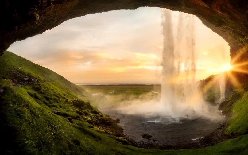 a view of a waterfall from inside a cave, a matte painting, by Johannes Voss, pexels contest winner, romanticism, iceland hills in the background, morning golden hour, extreme panoramic, bubbling geysers