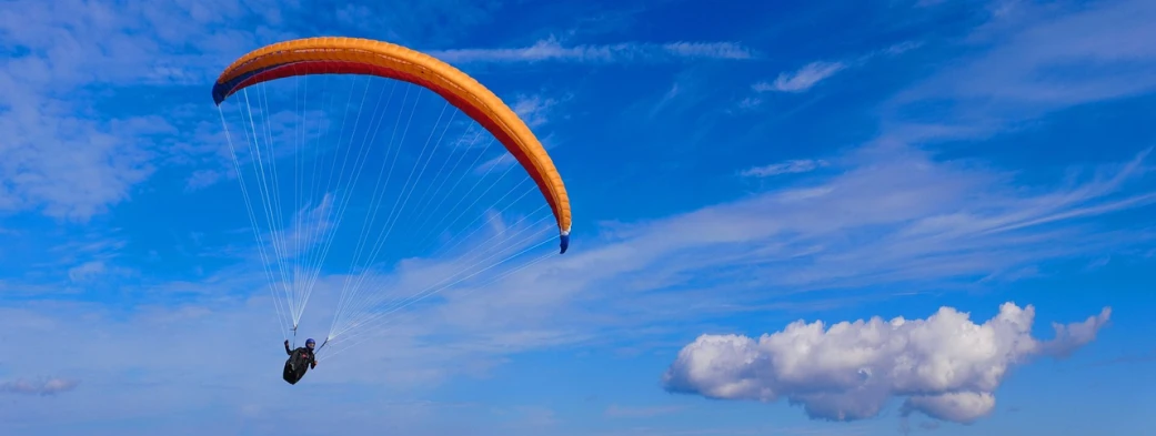 a person that is in the air with a parachute, a picture, trending on pixabay, fine art, orange and blue sky, ornithopter, taken with a pentax1000, sport