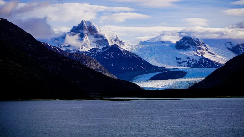 a large body of water with mountains in the background, a photo, by Juan Carlos Stekelman, blue glacier, taken with my nikon d 3, menacing!!!, visible from afar!!