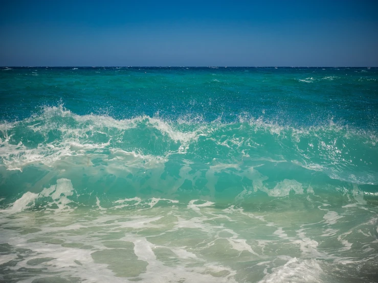 a person riding a surfboard on a wave in the ocean, a picture, shutterstock, fine art, varadero beach, blue and cyan scheme, waves crashing in the sea, glistening seafoam