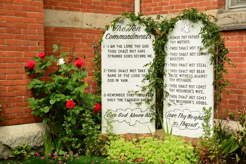a memorial plaque in front of a brick building, a photo, by Brenda Chamberlain, shutterstock, biblical, graveyard tombstones, vine covered, from wheaton illinois