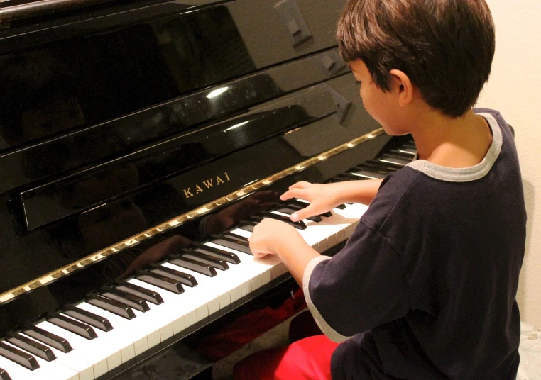 a young boy sitting in front of a piano, by Scott M. Fischer, pixabay, file photo, hana yata, kawaai, playing piano