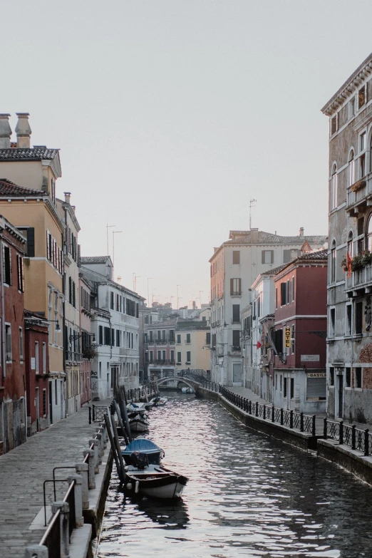 a river running through a city next to tall buildings, a picture, pexels contest winner, renaissance, venice biennale, early morning mood, windows and walls :5, faded red colors