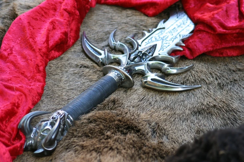 a sword laying on top of a red blanket, inspired by János Saxon-Szász, deviantart, hurufiyya, detailed sharp metal claws, from world of warcraft, black draconic - leather, highly detailed product photo