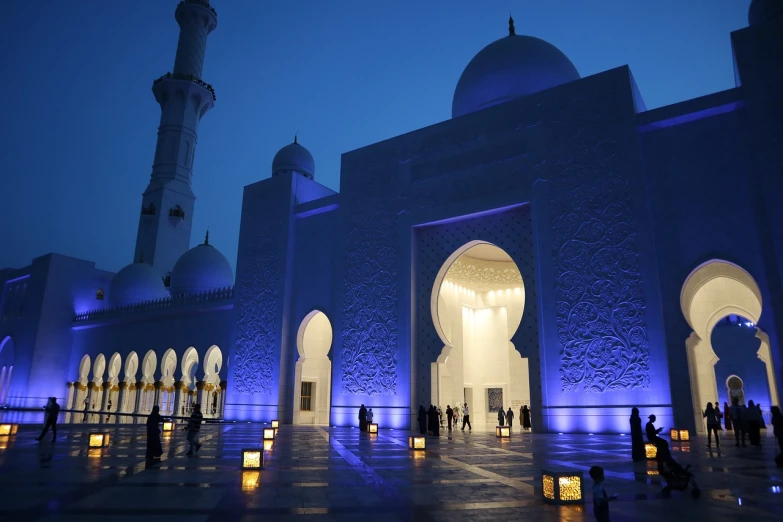 a group of people standing in front of a white building, a picture, by Sheikh Hamdullah, shutterstock, hurufiyya, blue and purle lighting, candlelit, morning atmosphere, inside a grand