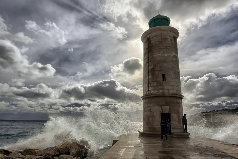 a couple of people that are standing in front of a lighthouse, a picture, by Pedro Pedraja, turbulent sea, hdr photo, split near the left, afp