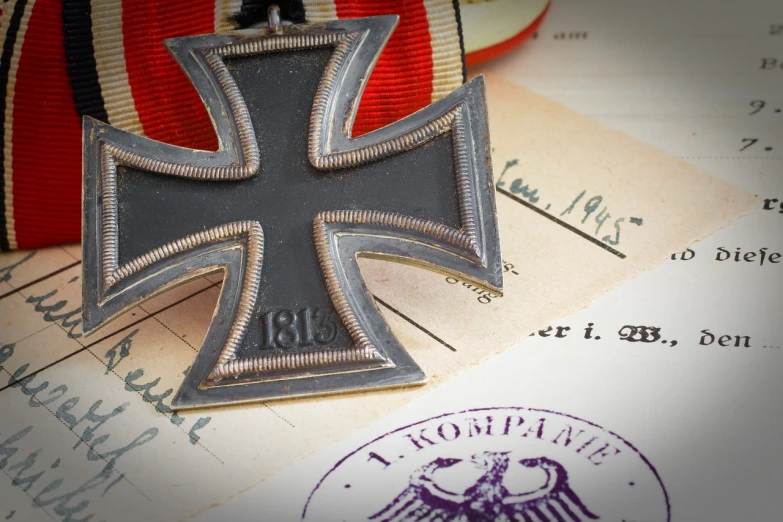 a metal cross sitting on top of a piece of paper, a portrait, by Ulrich Leman, shutterstock contest winner, imperial military, badge on collar, auction catalogue photo, heavy vignette!