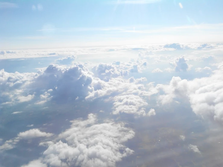 a view of the sky and clouds from an airplane, lots of white cotton, loots of clouds, high above the ground, atmospheric ”