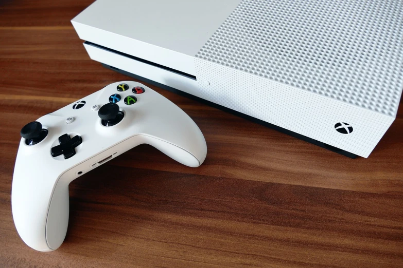 a video game controller sitting on top of a wooden table, pixabay, an the first xbox, sleek white, the console is tall and imposing, 4 k product photo