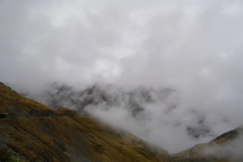 a group of people standing on top of a mountain, by Werner Andermatt, hurufiyya, low clouds after rain, high detail photo of a deserted, autumn mountains, new zealand landscape