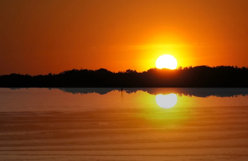 the sun is setting over a body of water, a photo, by Jan Rustem, shutterstock, mirrored, orange sun set, lagoon, taken with my nikon d 3