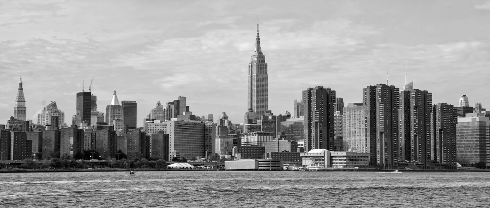 a black and white photo of a city skyline, a black and white photo, fine art, empire state building, viewed from the ocean, vertical orientation, high resolution