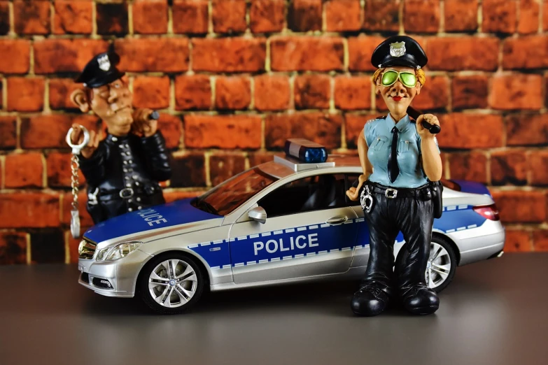 a figurine of a police officer next to a toy car, a picture, by Adam Marczyński, pixabay, photorealism, posing in disguise among humans, police station, joke, actress