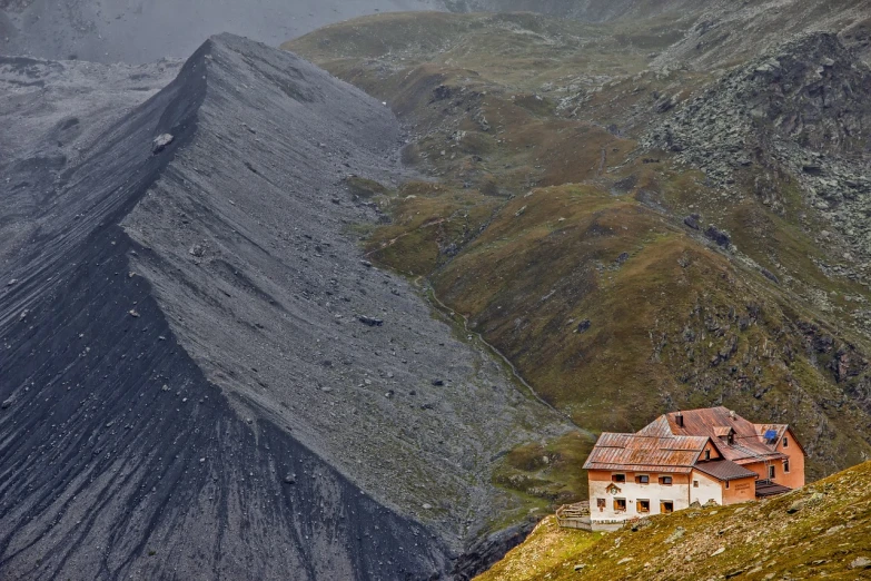 a house sitting on the side of a mountain, a tilt shift photo, by Werner Andermatt, coal dust, vladimir pchelin, distant photo, austria