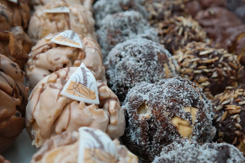 a bunch of doughnuts sitting next to each other, a picture, baroque, market, rocky roads, close - up photo, fibbonacci