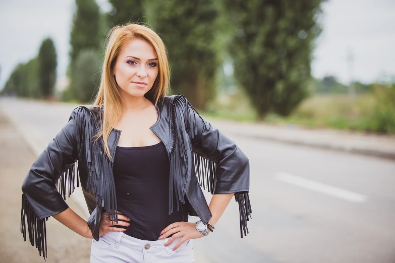 a woman standing on the side of a road with her hands on her hips, a portrait, by Ivan Grohar, tachisme, dressed in short leather jacket, beautiful sexy woman photo