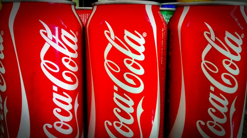 a group of coke cans sitting next to each other, a stock photo, inspired by Dorothy Coke, shutterstock, egypt, compressed jpeg, postprocessed, usa-sep 20