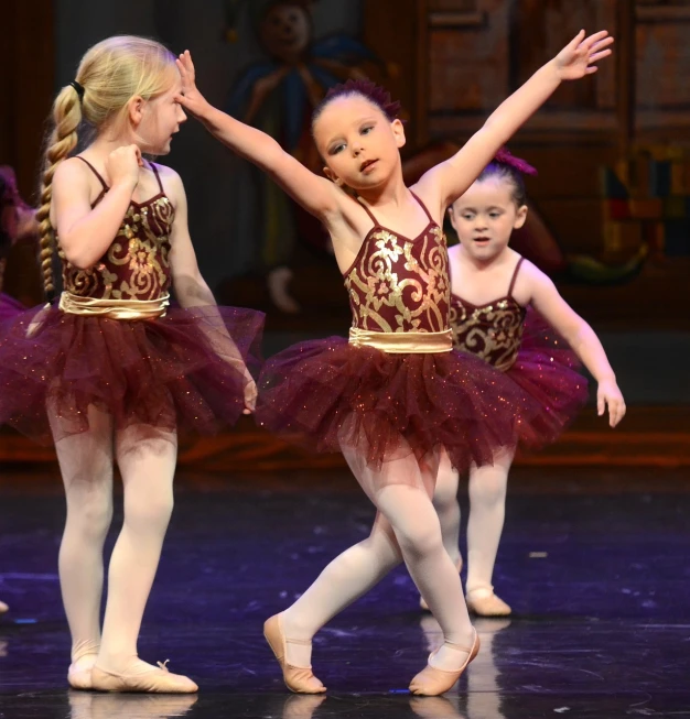 a group of little girls standing on top of a stage, arabesque, brown and magenta color scheme, trio, sally, holiday season