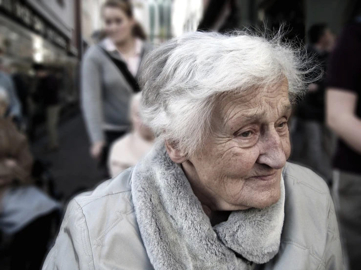 a close up of a person wearing a scarf, by Matija Jama, pexels, realism, an old lady, in a street, relaxed dwarf with white hair, time dragging on for too long