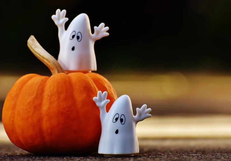 a couple of ghost figurines sitting next to a pumpkin, a picture, pixabay, happening, grand!