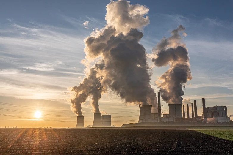 a factory with a lot of smoke coming out of it, a picture, by Jürg Kreienbühl, golden hour sun, power plants, photo from 2022, coal