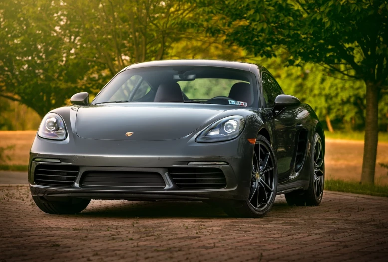 a porsche sports car parked on the side of a road, a portrait, inspired by Harry Haenigsen, pexels contest winner, photorealism, 4 k vertical wallpaper, gunmetal grey, long front end, usa-sep 20