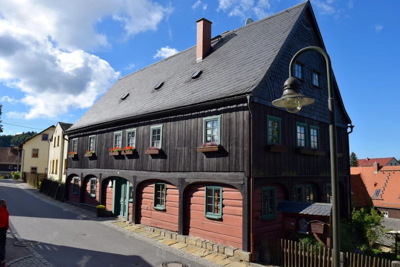 a brown house sitting on the side of a road, by Jörg Immendorff, flickr, heidelberg school, a multidimensional cozy tavern, gambrel roof, atlach - nacha, exterior view