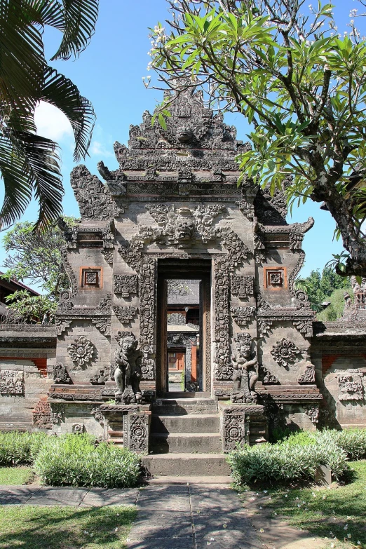 a person standing in the doorway of a building, inspired by I Ketut Soki, flickr, sumatraism, beautiful ancient garden behind, architecture carved, full front view, hd —h 1024