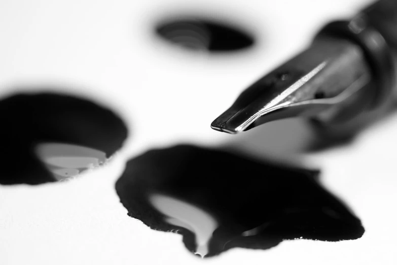 a fountain pen sitting on top of a white table, an ink drawing, inspired by Lucio Fontana, unsplash, process art, mirror dripping droplet, consist of shadow, covered with ferrofluid. dslr, detail shots