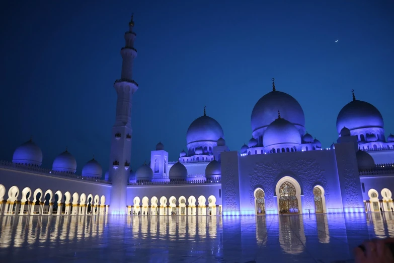 a large white building lit up with blue lights, a picture, by Sheikh Hamdullah, hurufiyya, domes, moody blue lighting, picturesque, indigo