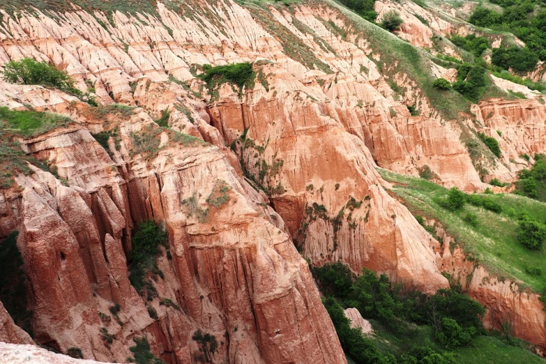 a man riding a horse on top of a lush green hillside, by Alexander Fedosav, flickr, figuration libre, red sandstone natural sculptures, baotou china, detail texture, chalk cliffs above