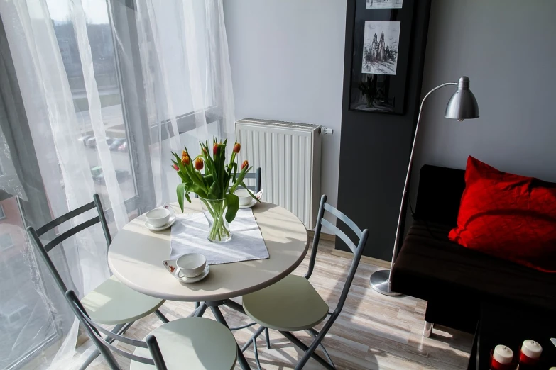 a table with a vase of tulips on top of it, by Walenty Wańkowicz, pixabay, bauhaus, open plan, small room, apartments, benjamin vnuk