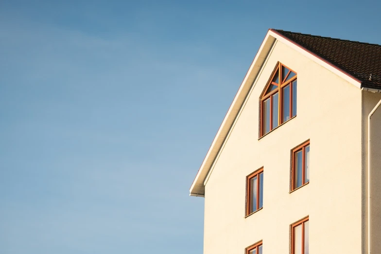 a clock that is on the side of a building, unsplash, modernism, simple gable roofs, white houses, evening sunlight, stucco walls