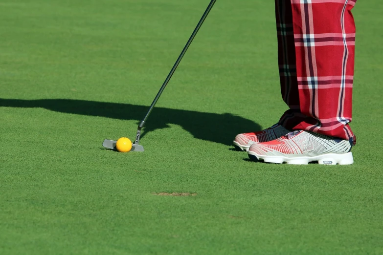 a man standing on top of a green field next to a golf ball, a photo, tuning, close - up photo