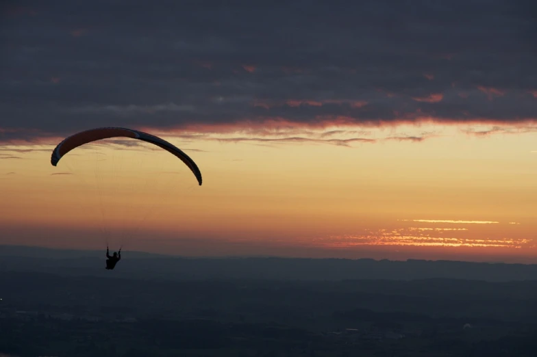 a person that is in the air with a parachute, by Julian Allen, pexels contest winner, sunset panorama, filmed in 70mm, 2014, twilight ; wide shot