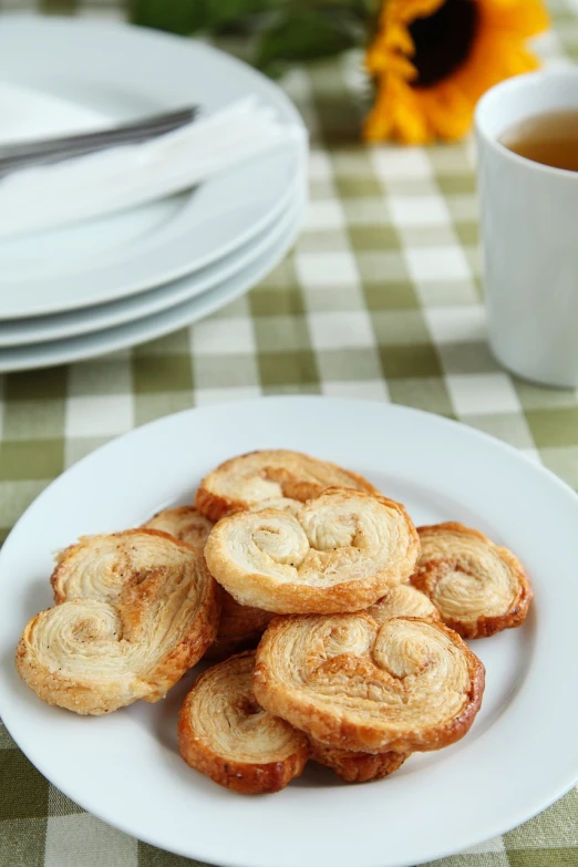 a white plate topped with cookies next to a cup of coffee, flickr, dau-al-set, twirls, banana, 5 mm, baking cookies