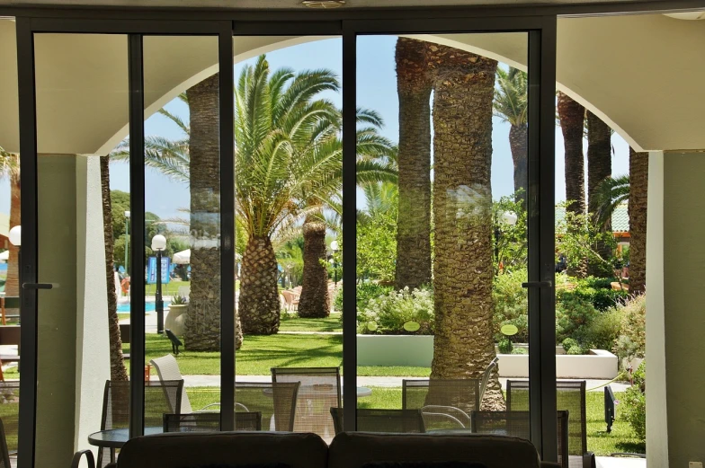 a living room filled with furniture and palm trees, arabesque, view from inside, reportage photo, resort, sicilian