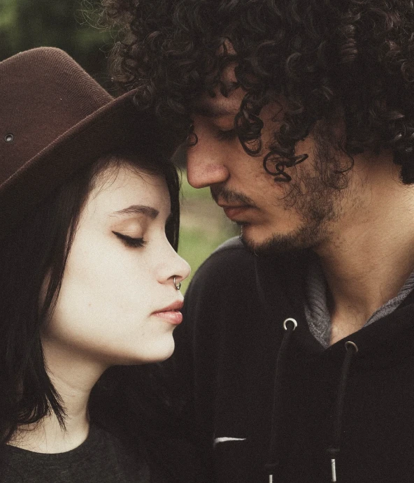 a man and a woman standing next to each other, a picture, tumblr, romanticism, curly black hair, beanie, tenderness, pale - skinned