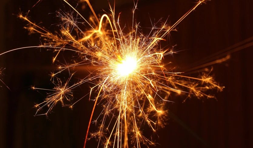 a close up of a sparkler in the dark, istockphoto, large electrical gold sparks, blog-photo, bright sparks