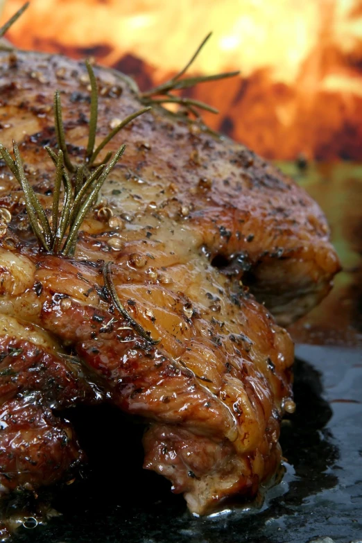 a piece of meat with a sprig of rosemary on top of it, by Matt Cavotta, istockphoto, fire lit, amazing background, duck