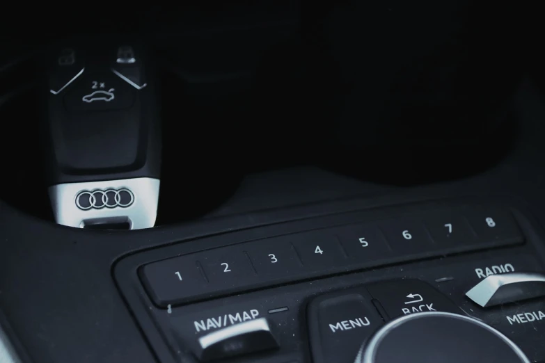 a close up of a remote control in a car, by Karl Buesgen, unsplash, denim blue audi a4 b6, banner, dark interior, instagram story