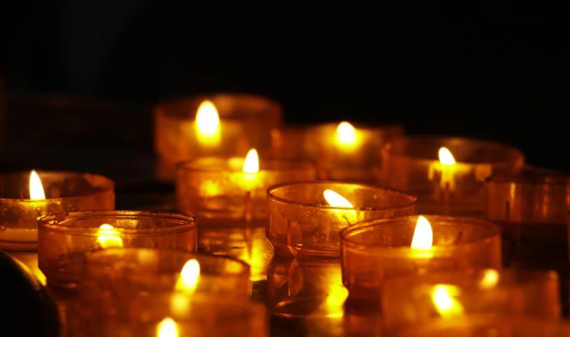 a group of lit candles sitting on top of a table, a picture, hurufiyya, light through glass, profile image, yellow lights, profile picture