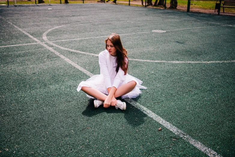 a girl in a white dress sitting on a tennis court, inspired by Elsa Bleda, school girl, casual photography, on a soccer field, childish look