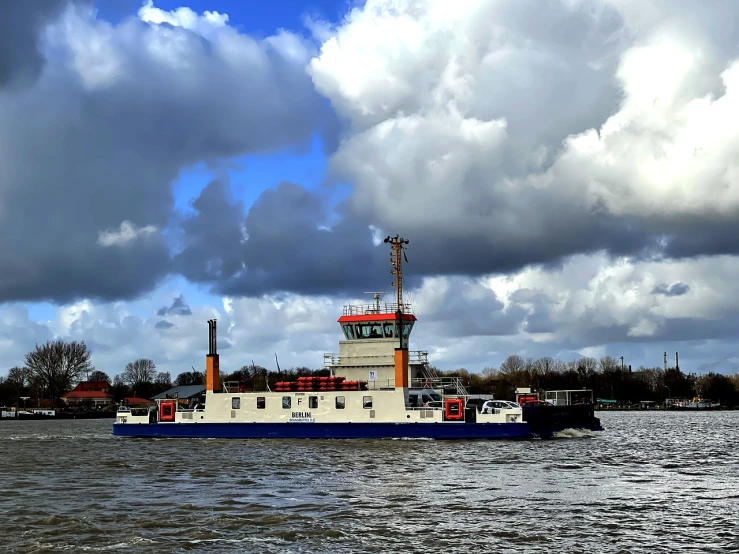 a blue and white boat on a body of water, a portrait, big smoke clouds visible, helmond, 2 0 2 2 photo, bucklebury ferry