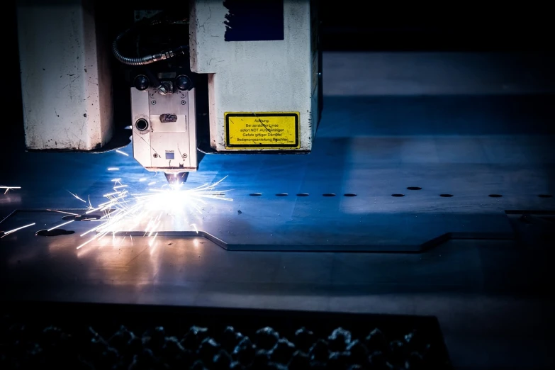 a machine cutting a piece of metal with sparks, an engraving, by Matt Cavotta, pexels, holography, commercial product photography, blue print, laser beam ; outdoor, stock photo