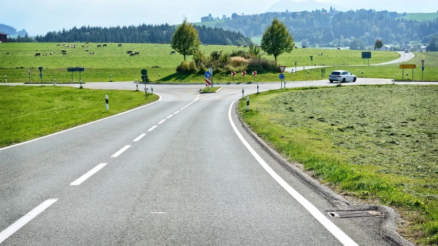 a car driving down a curvy country road, a picture, by Hans Schwarz, shutterstock, intersection, without green grass, germany. wide shot, cars on the road
