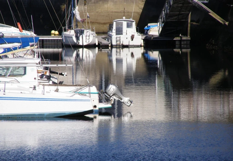 a number of boats in a body of water, a photo, flickr, photorealism, reflections. shady, bridge, hestiasula head, cheeky!!!