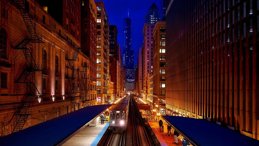 a train traveling down train tracks next to tall buildings, a photo, by Andrew Domachowski, city night, chicago, beautiful random images, city of pristine colors